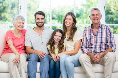 Portrait of happy family sitting on sofa at home